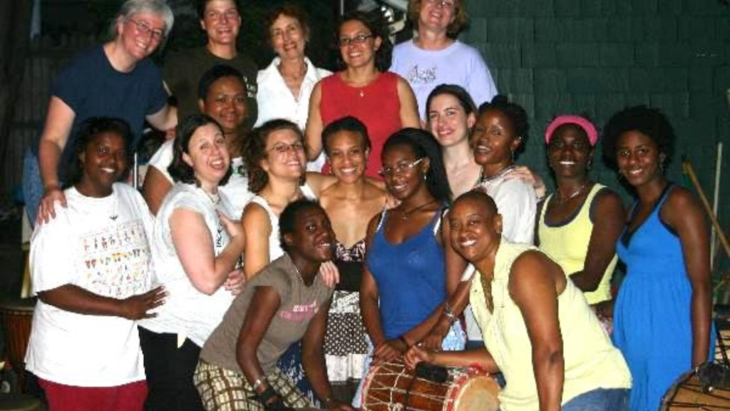 The first group photo of Bele Bele Rhythm Collective, smiling members posing around a drum