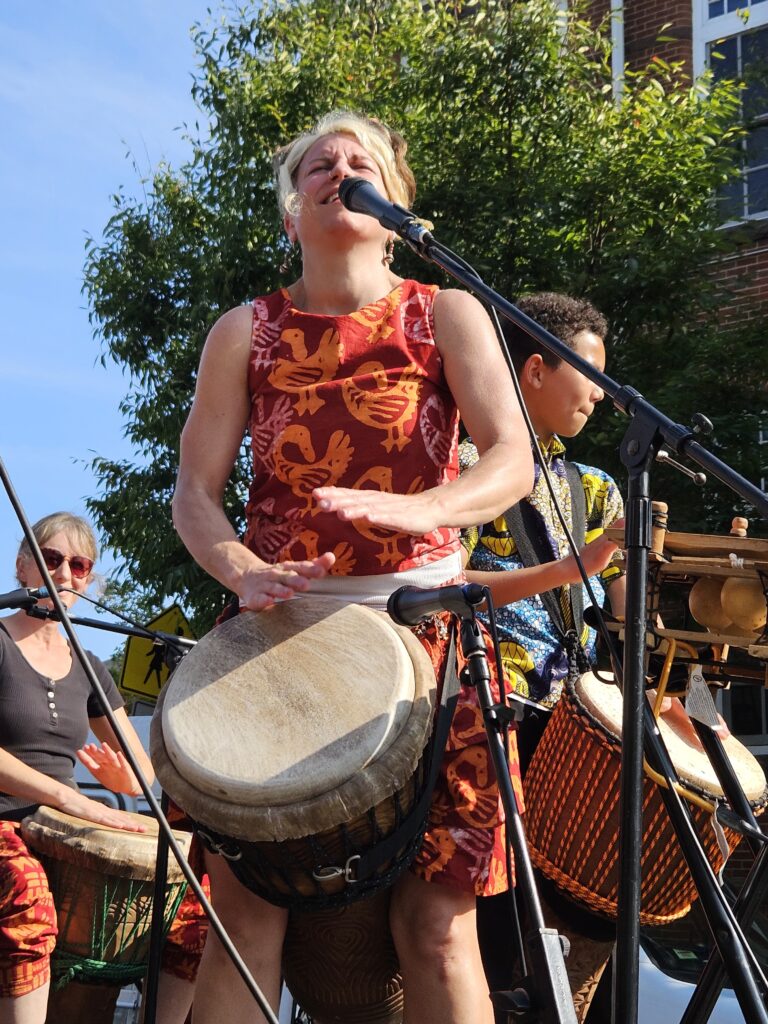 Kristen drums at a performance with Bele Bele Rhythm Collective