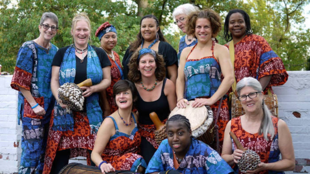 Bele Bele Rhythm Collective members pose for a group photo wearing batik clothing