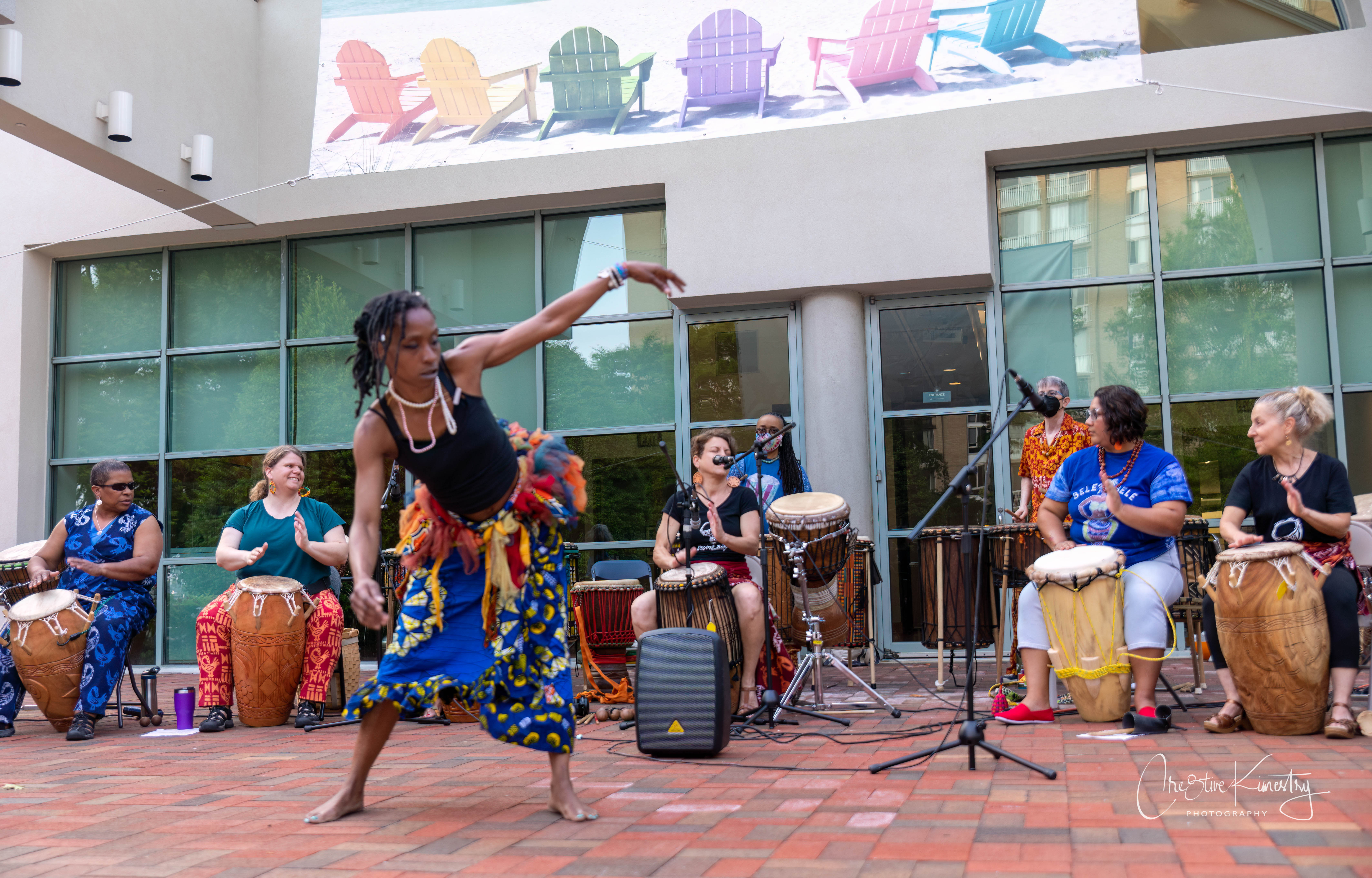 Bele Bele member wearing traditional West African clothing and dancing while others play drums